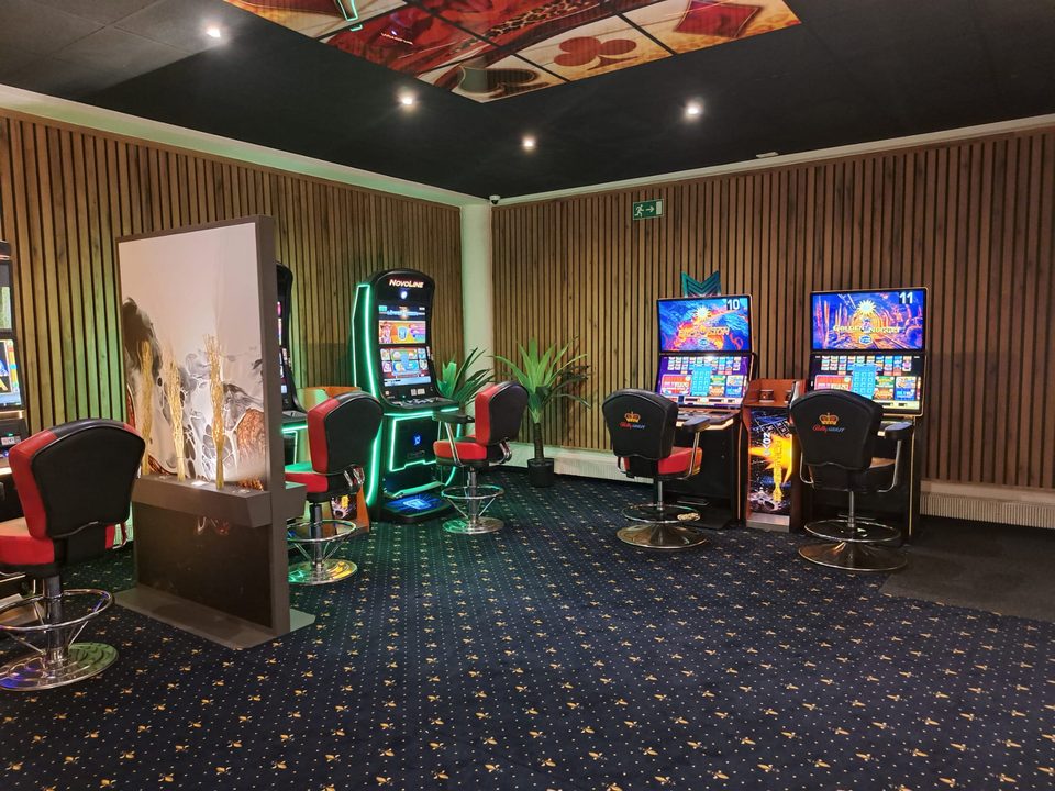 Geldspielgeräte mit roten Sesseln unter farbiger Deckenbeleuchtung in der Spielhalle Voerde
