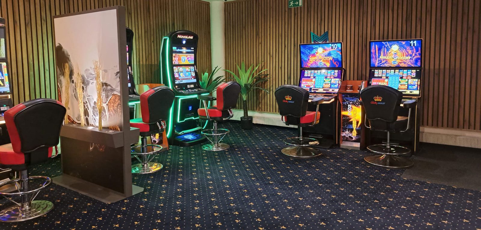 Spielautomaten an der Holzwand mit roten Ledersesseln in der Spielhalle Voerde